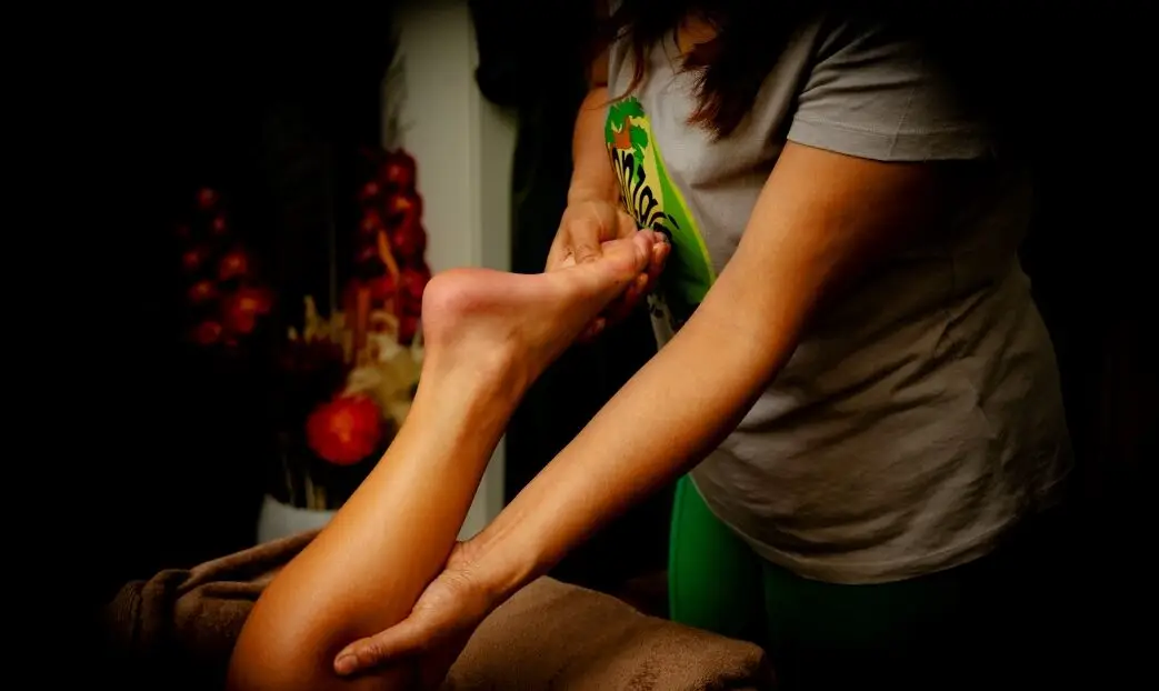 Een vrouw die persoon haar voet massage behandeling doet