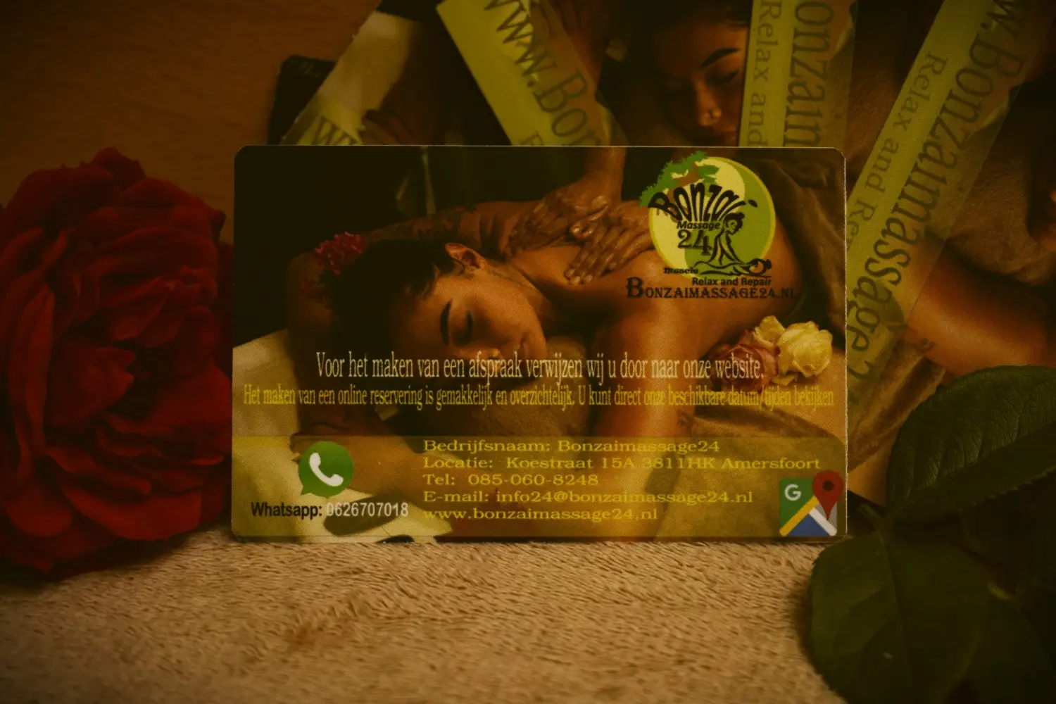 Visitekaartje van contact Bonzaimassage24 met logo, contactgegevens en een afbeelding van een ontspanningsmassage. Bevat adres in Amersfoort, telefoonnummer, WhatsApp-nummer en verwijzing naar online reserveren via de website www.bonzaimassage24.nl.